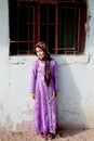 Unidentified Afghan Girl with traditional Dress standing by the wall in Ovakent, Hatay, Turkey