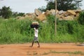 Unidentified african boy carrying a suitcase in his head Royalty Free Stock Photo