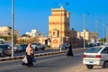 Unidentified arabic muslim woman in hijab crossing the road with shopping bags in hands