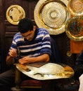 Unidentified Arabic people make traditional metal plate in a mar