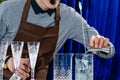 Unidentified barman adding liquid in a glass at the bar counter