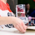 Unidentified barman holding an ice glass with berries alcohol co