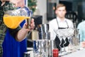 Unidentified barman pouring juice in a metal glass