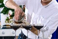 Unidentified barman pouring liquid in martini glass