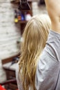 Unidentified blonde woman dries wet hair with Hairdryer