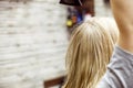 Unidentified blonde woman dries wet hair with Hairdryer