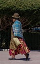 Unidentified bolivian woman wearing traditional clothes walks arround the square in Copacabana, Bolivia