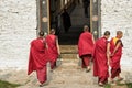 Unidentified buddhist monks with traditional robes are entering the Punakha Dzong monastery, Punakha, Bhutan