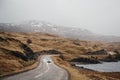 Unidentified car driving on a road going through Scottish Highlands near Lochinver, Scotland.