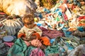 Unidentified child is sitting while her parents are working on dump, Dec 22, 2013 in Kathmandu, Nepal