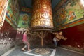 Unidentified children have fun with spinning Big Tibetan Buddhist prayer wheel at Boudhanath Stupa. Royalty Free Stock Photo