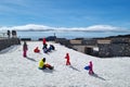 Unidentified children ride on a snowy hill near Etna, Italy