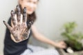 Unidentified cropped woman gardener shows soil on dirty hands while planting a tree in home garden. Concept of relaxing and hobby