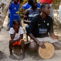 Unidentified Diola man plays on drums in Kaschouane village. Di