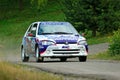 Unidentified drivers on a white and blue vintage Peugeot 106 racing car