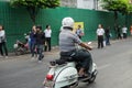 Unidentified driving a Vespa motorcycle