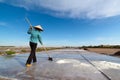 An unidentified farmers are harvesting salt