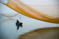 Unidentified fisher man check his nets in early morning on river in Hoian, Vietnam.