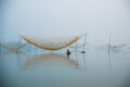 Unidentified fisher man check his nets in early morning on river in Hoian, Vietnam.