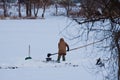 Unidentified fisherman puts mud in a metal sieve to wash out bloodworm to use it as bait for predator fishing