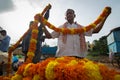 An unidentified flower seller buys marigold garlands from a wholesaler at Local market in Hospet ,Karnataka South India.