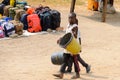 Unidentified Ghanaian kids carry buckets on the street in Elmin