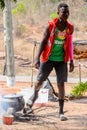 Unidentified Ghanaian man in colored clothes cooks on fire.