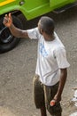 Unidentified Ghanaian man in white shirt raises one hand and ho