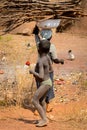 Unidentified Ghanaian woman carries wood over her head in a loc