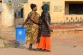 Unidentified Ghanaian women in colored dresses walk in local vi