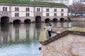 Unidentified girl and Egyptian duck standing in front of the Vauban Dam in Strasbourg