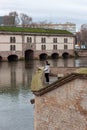 Unidentified girl and Egyptian duck standing in front of the Vauban Dam in Strasbourg
