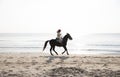 Unidentified girl riding a horse by the beach at morning sunrise at Huahin beach of Prachuap Khiri Khan,Thailand Royalty Free Stock Photo