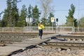 Unidentified girl running railways at a pedestrian crossing on a green traffic light signal