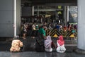 Unidentified girls sitting on step, and unidentified people waiting for a bus at Siam center