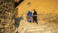 Unidentified iranian couple in traditional persian clothes climbing stairs, Masuleh, Gilan province, Iran