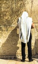 Unidentified jewish worshiper in tallith and tefillin praying at the Wailing Wall an important jewish religious site