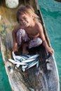 Unidentified kid on the canoes with fish at Mabul island