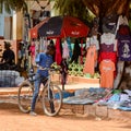 Unidentified local boy on bicycle looks at the counter with goo