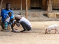 Unidentified local boy cures his friend's foot in a village of