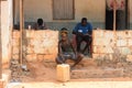 Unidentified local man in a hat sits on stairs in a village of