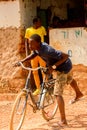 Unidentified local man pulls a bicycle in a village in Guinea B