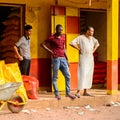 Unidentified local three men stand near the stock in a village