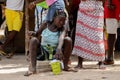 Unidentified local woman with braids sits on the bag in the Eti