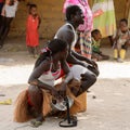 Unidentified local woman with braids sits on the ground in the