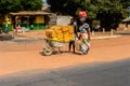 Unidentified local woman pulls a cart with jerrycans in a villa