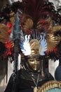 An unidentified man and dresses an elaborate fancy dresses with gold masks, red and black feather hat during Venice Carnival