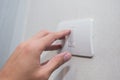 Unidentified man hand with finger on light switch turn on turn off lights. Royalty Free Stock Photo