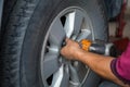 Unidentified man hand making tyre fitting with air compressed wrench screwing up bolts