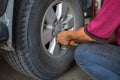 Unidentified man hand making tyre fitting with air compressed wrench screwing up bolts